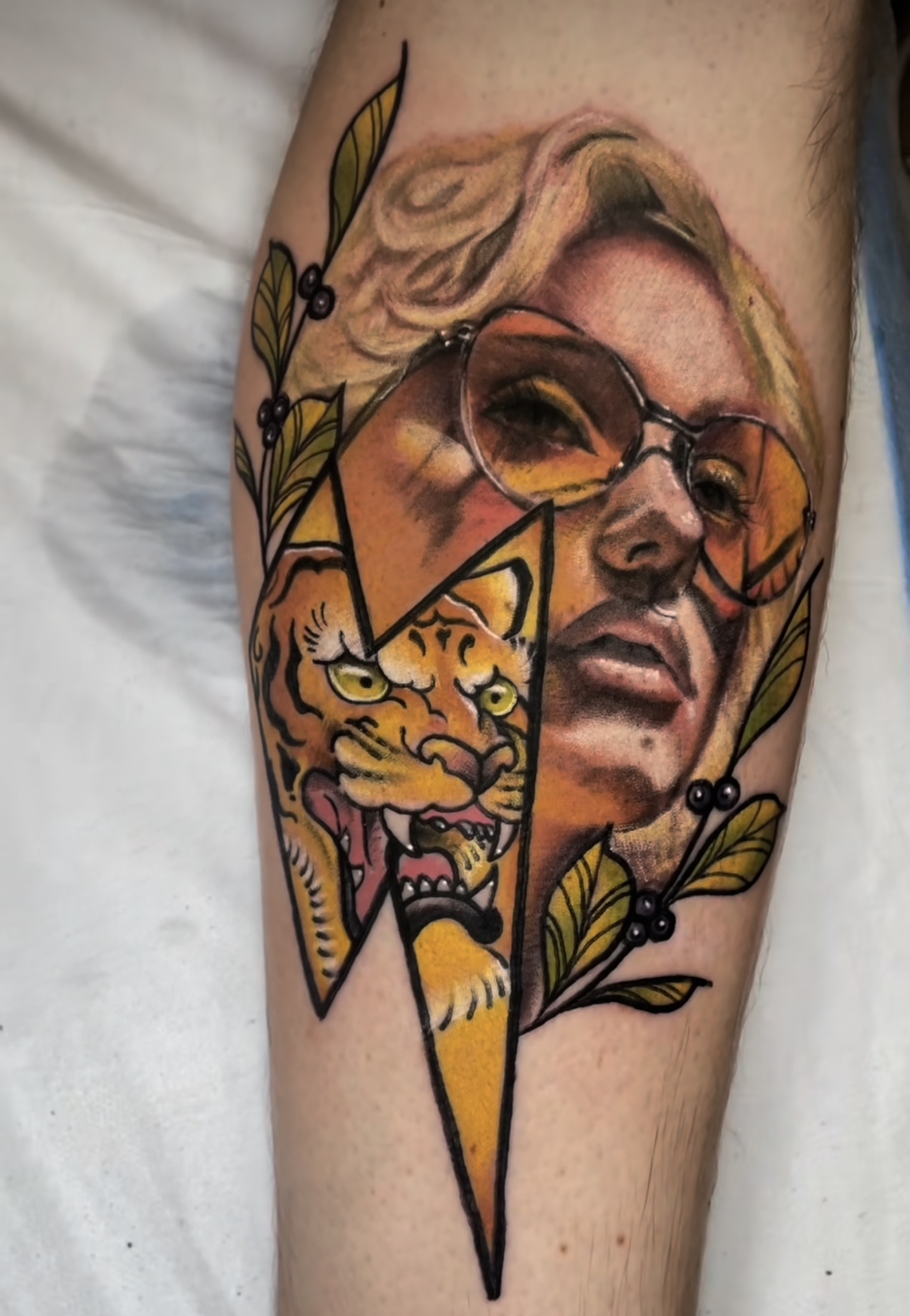Neo-traditional split portrait — half human face, half tiger — in bold colour.